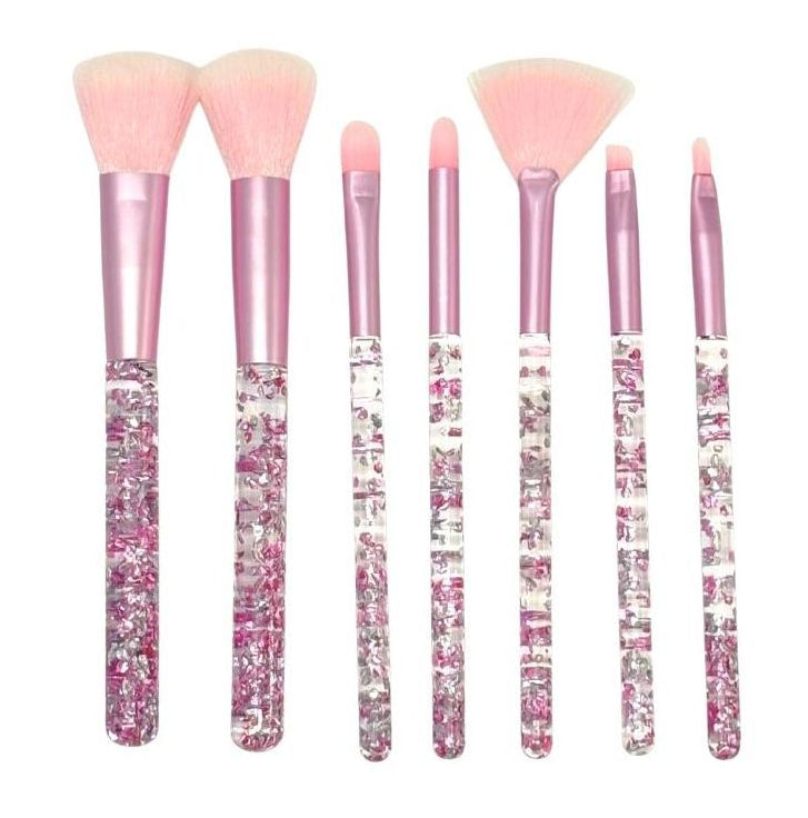 Set of makeup brushes with pink and glittery handles on a white background