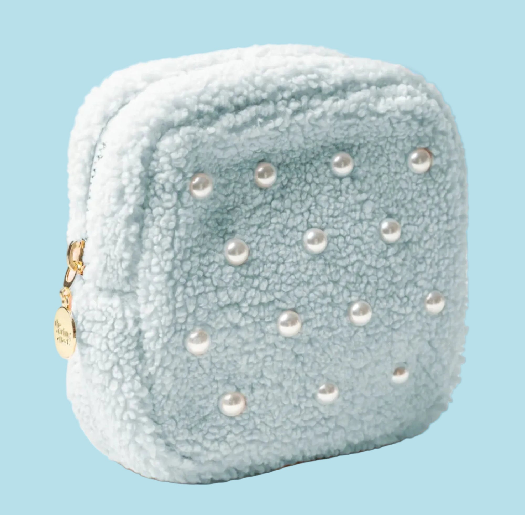 Light blue textured pouch with pearl-like embellishments on a beige background