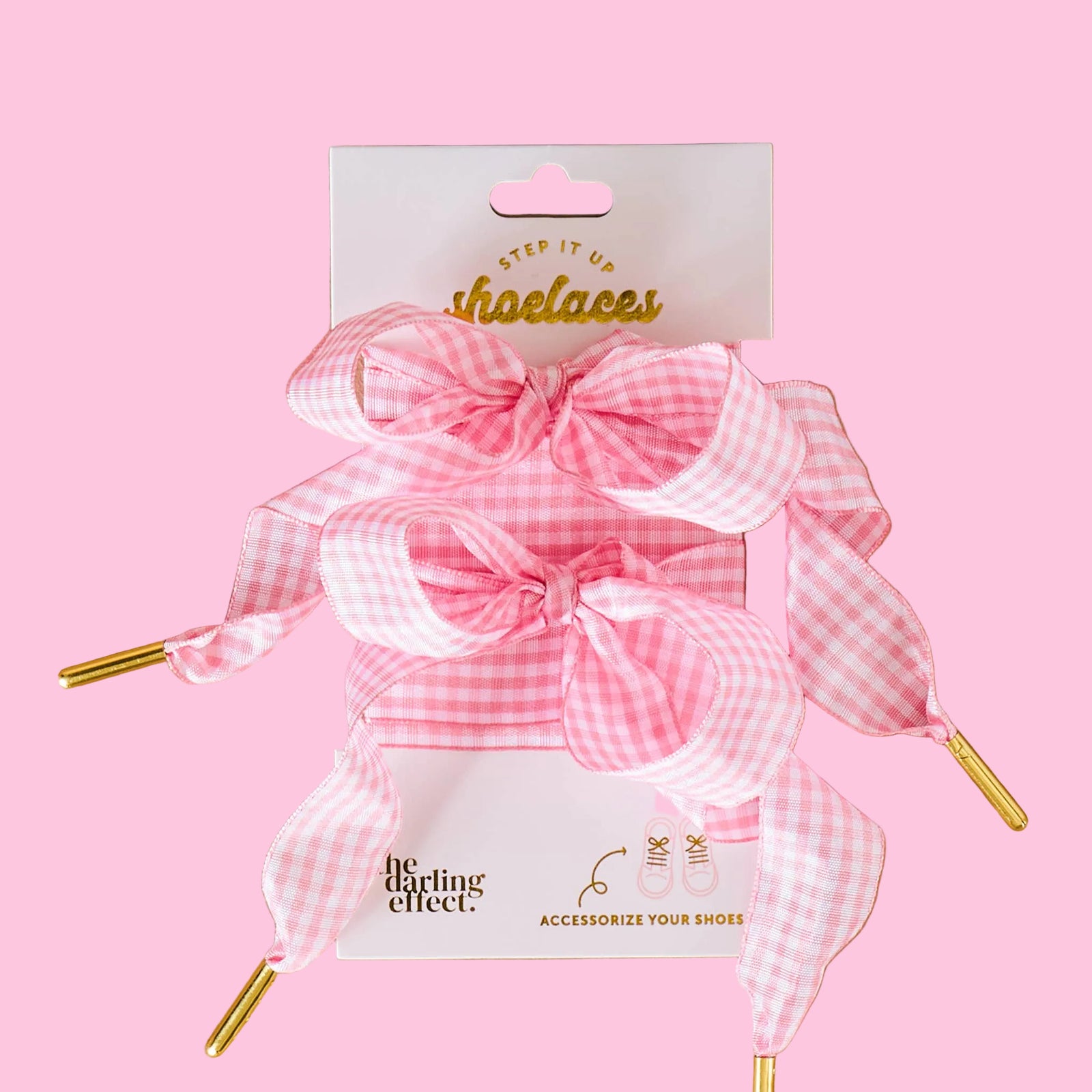 Pink checkered shoe laces with packaging on a beige background