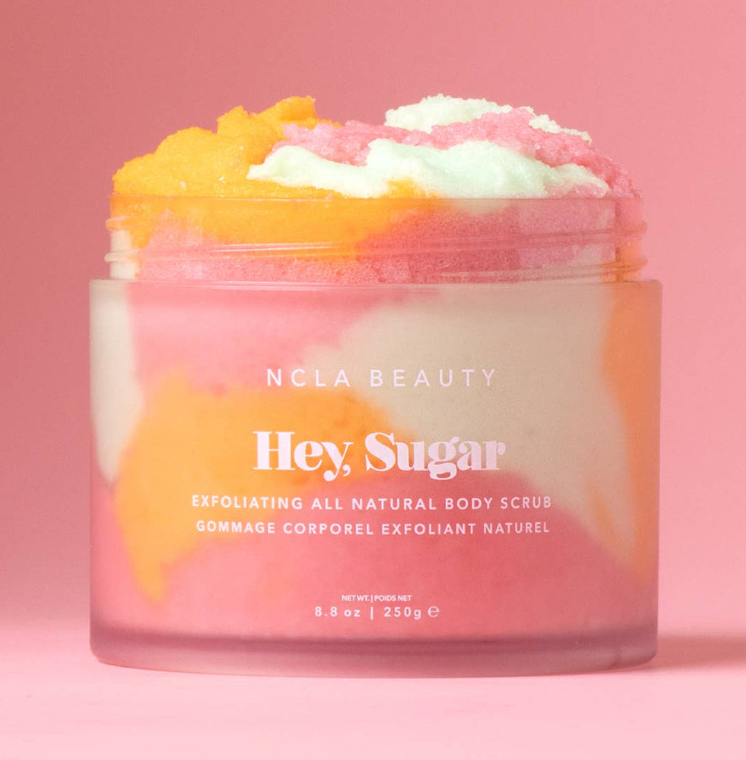 Jar of NCLA Beauty 'Hey Sugar' body scrub on a pink background
