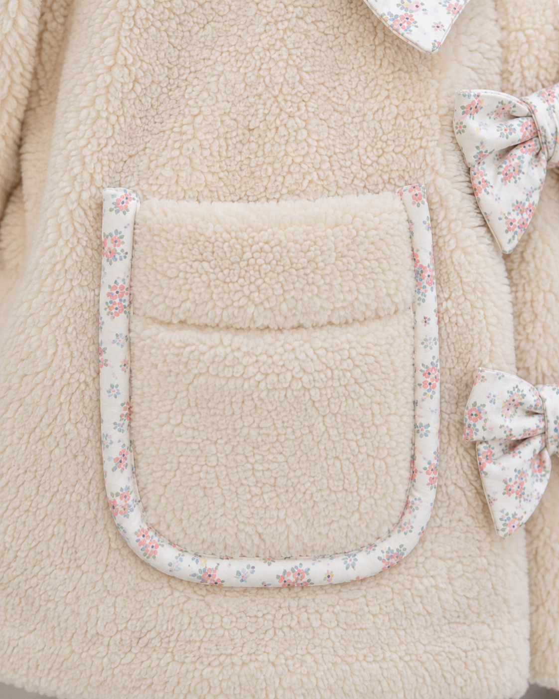 Floral trim detail on collar of ivory girls sherpa jacket