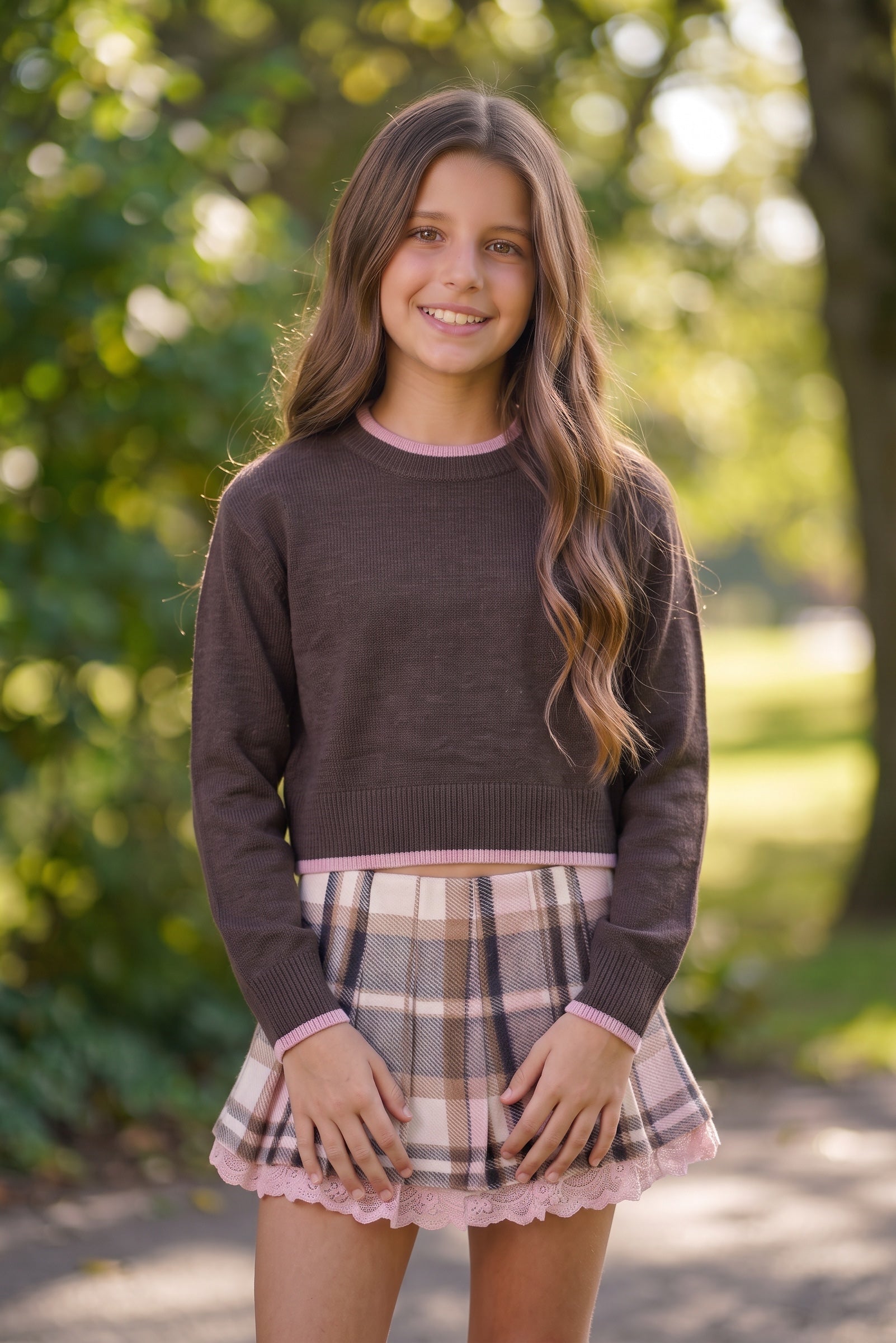 girl wearing a back to school look  from KatieJ boutique plaid skirt and coordinating chocolate and pink sweater