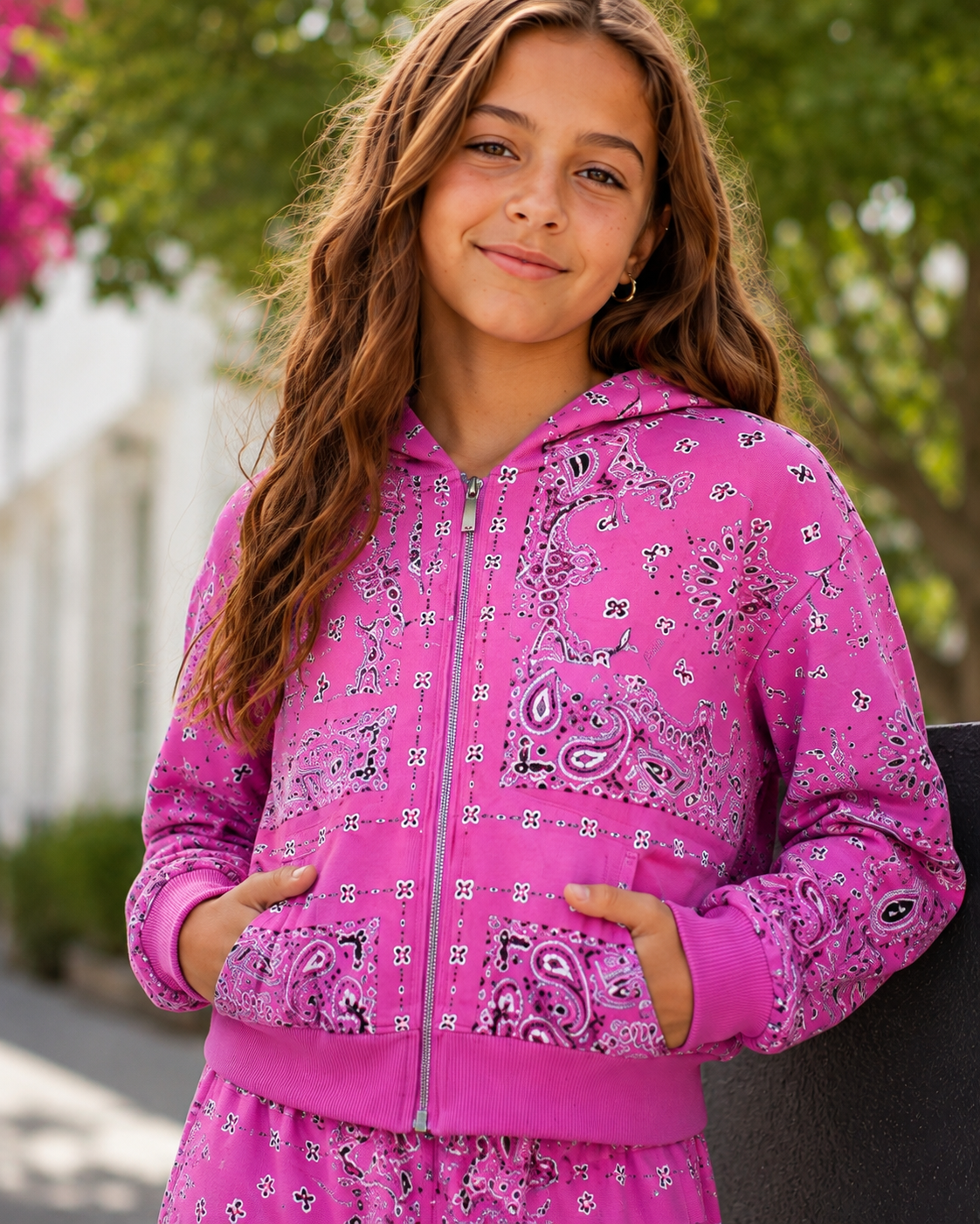 KatieJ NYC Haden hot pink bandana print zip hoodie modeled on a tween girl outdoors