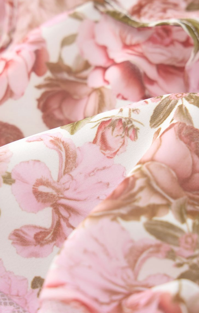 Girls luxury blush floral dress by Marlo Kids featuring frilled shoulder straps, delicate trim, and a flared mini skirt.