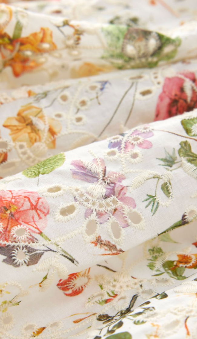 Girls luxury garden party dress by Marlo Kids featuring colorful floral embroidery, long puff sleeves and a tie waist.