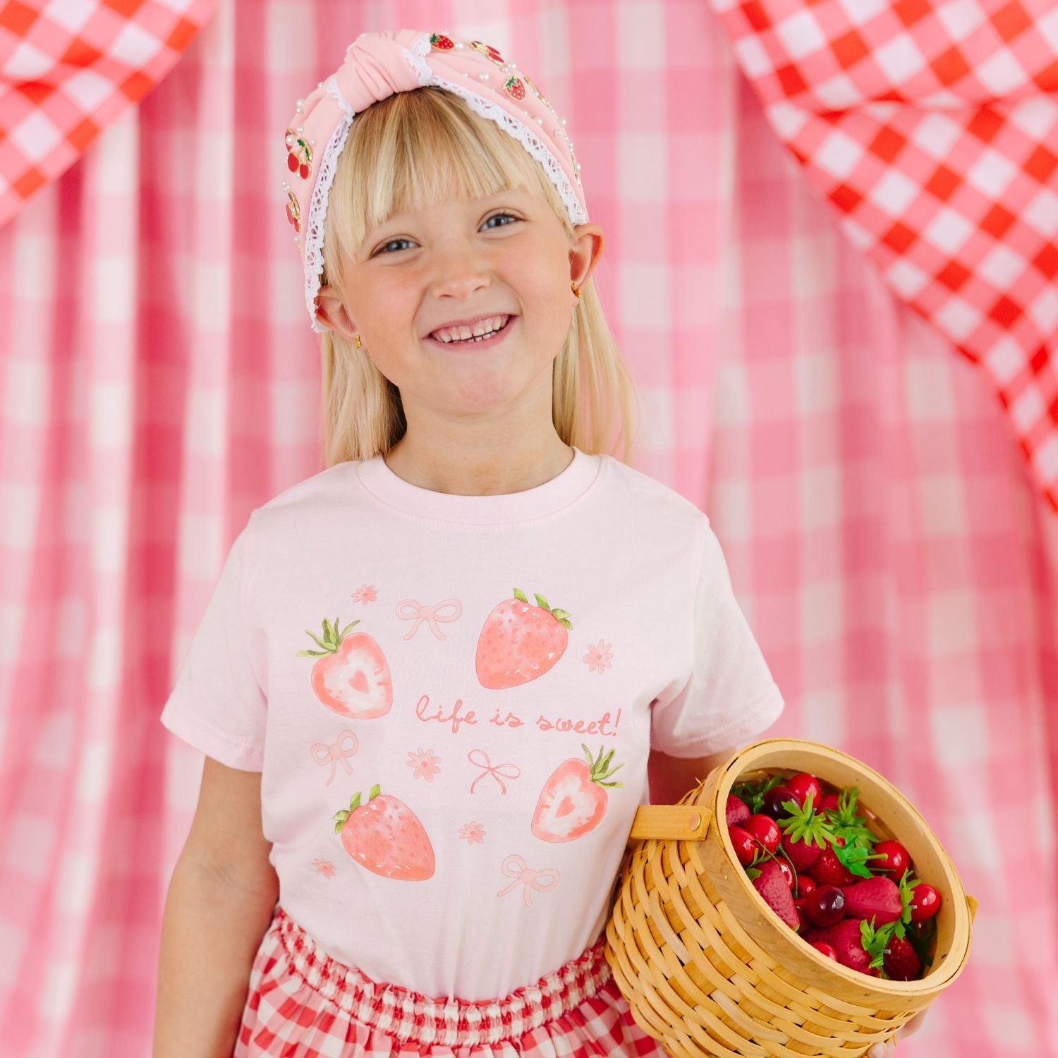 girl wearing a sweet wink pink tee with strawberries