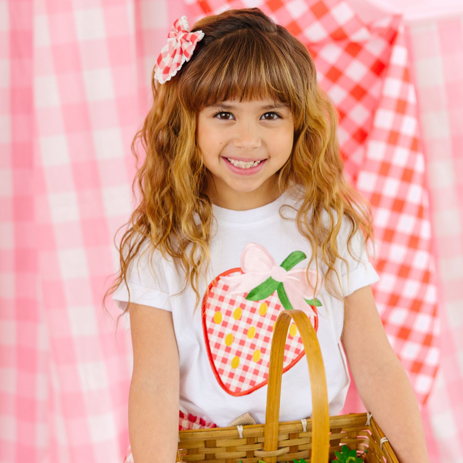 girl wearing a sweet wink strawberry tee holding a basket