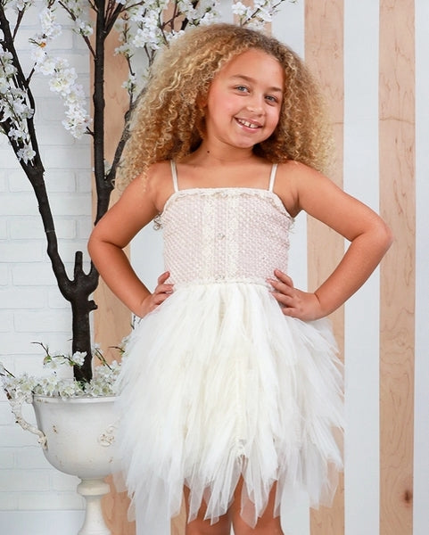 Girl wearing the Ooh! La, La! Couture Coco Emma Dress featuring a pink tweed bodice, crystal buttons, ivory lace trim, and cascading ivory tulle skirt.