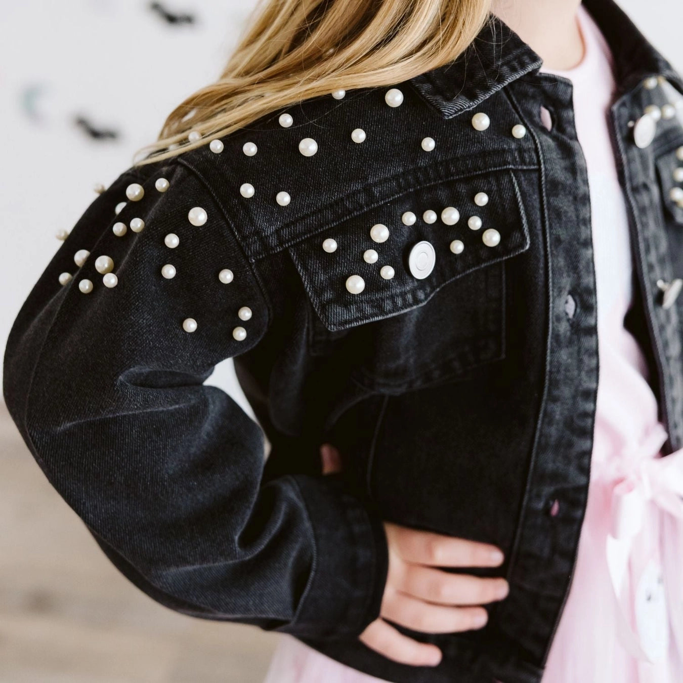 Front view of the Sweet Wink black pearl denim jacket for tween girls featuring pearl embellishments and classic button-front styling.