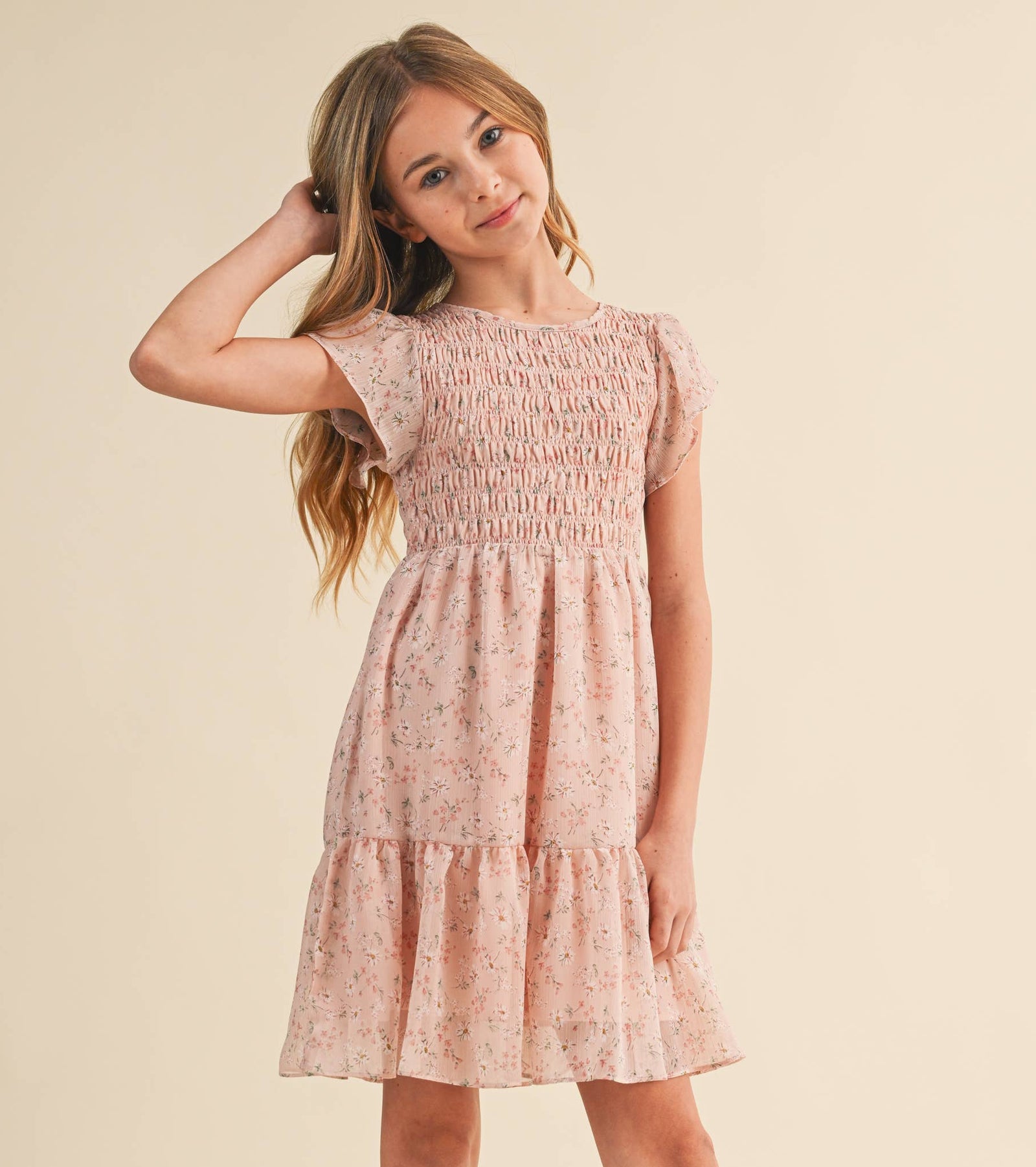 Young girl wearing a pink floral dress on a beige background