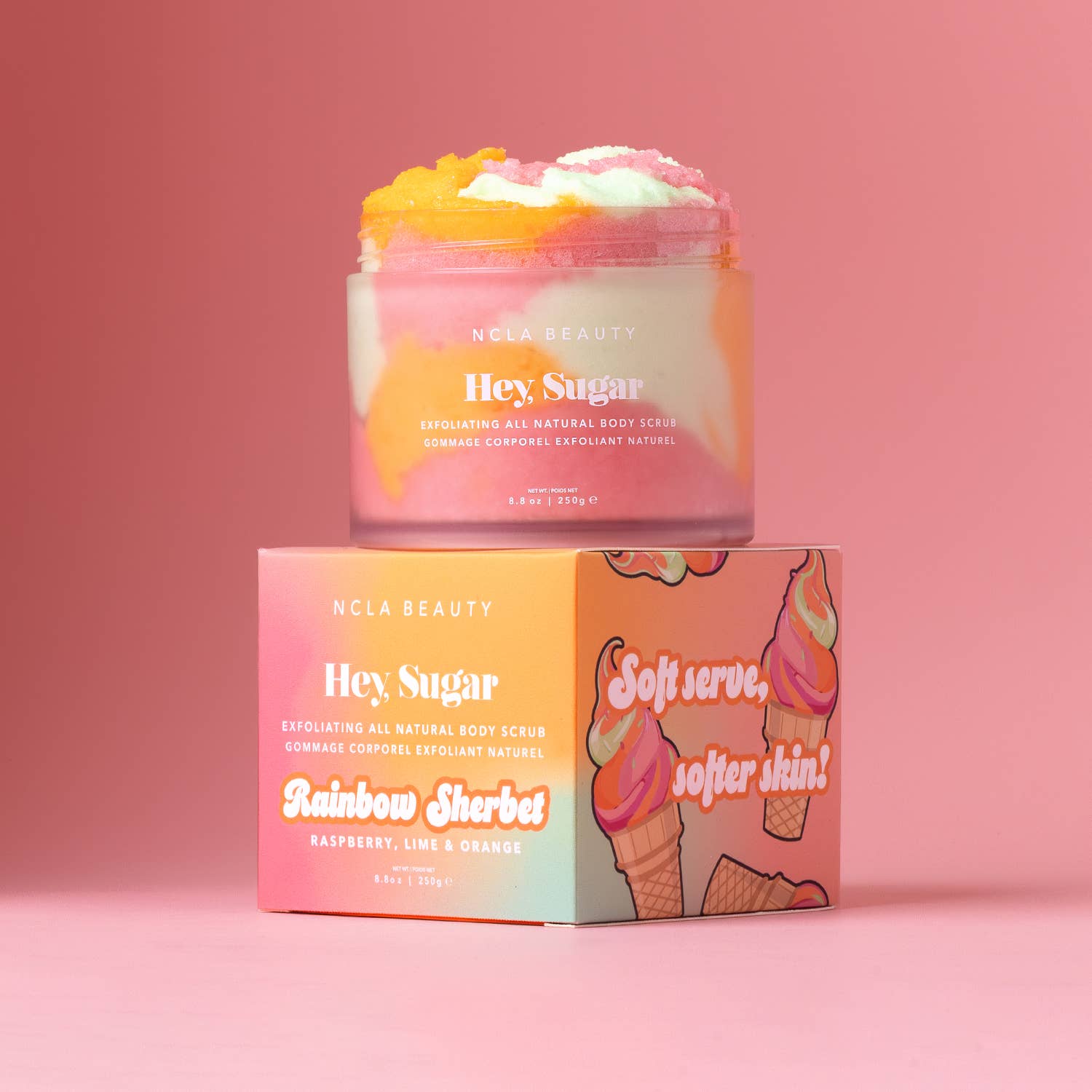 NCLA Beauty 'Hey Sugar' rainbow sherbet body scrub with packaging on a pink background