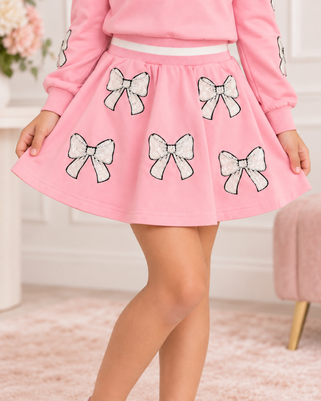 Girl modeling the Belle Cher baby pink sequin bow skirt
