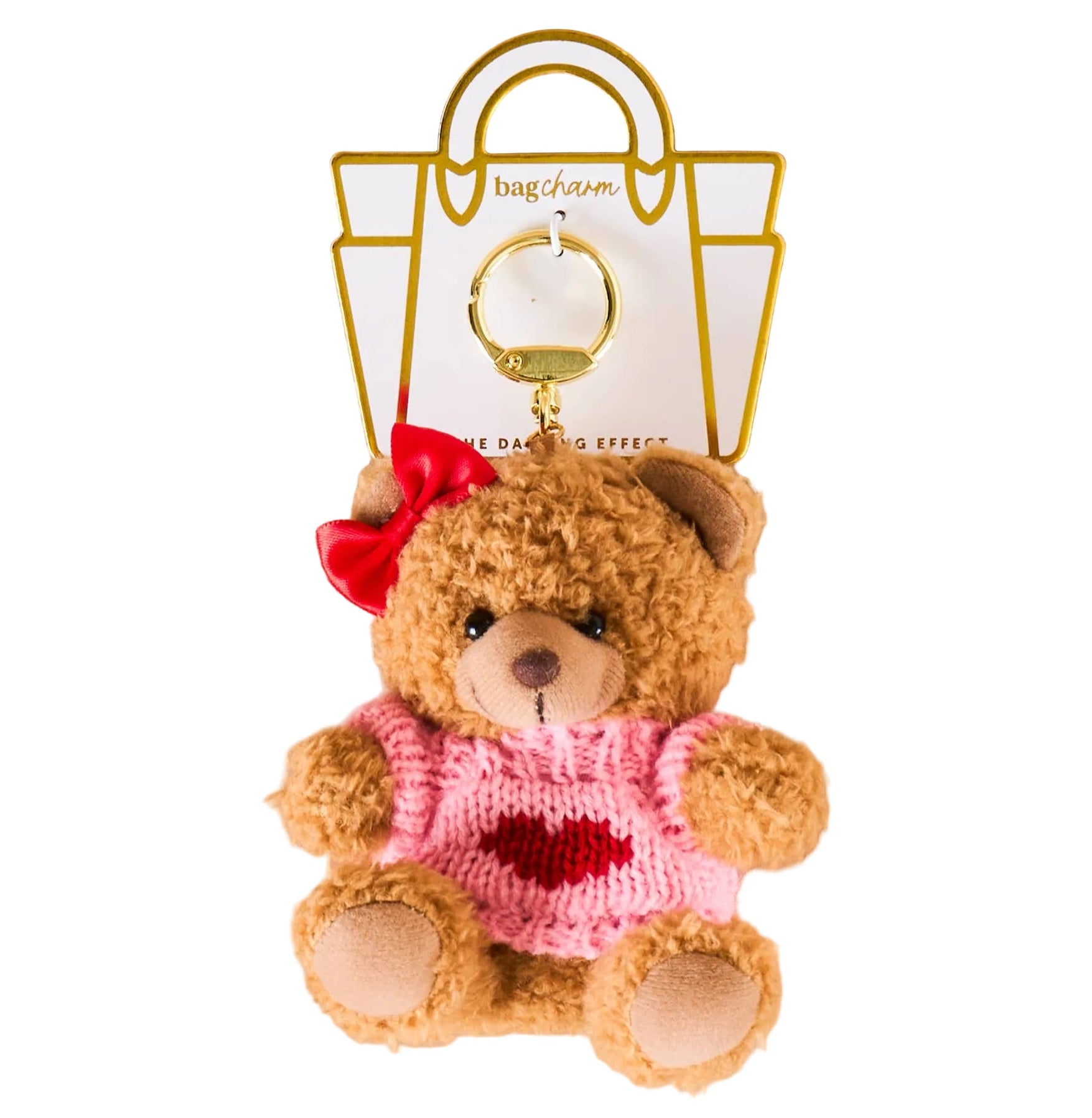 Teddy bear keychain with pink dress and red bow on a beige background