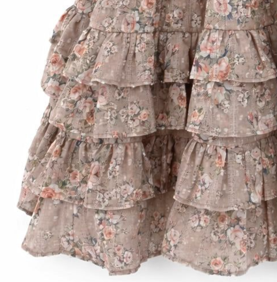 Close-up of a tiered ruffle skirt in a dusty taupe floral print with pink, peach, and green flowers on a white background.