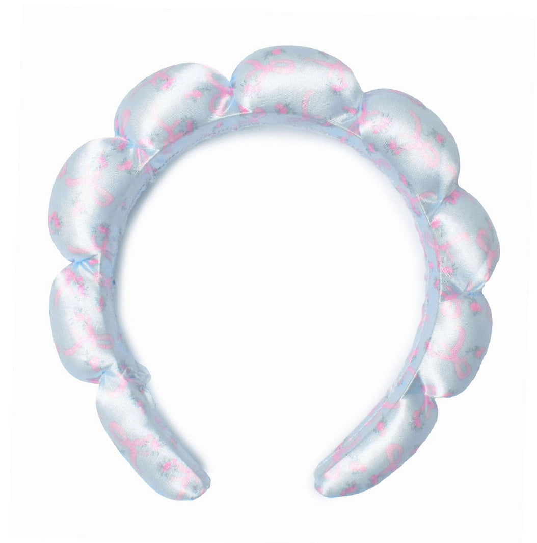 A light blue inflatable headband with a scalloped edge and a pink pattern, isolated on a white background.
