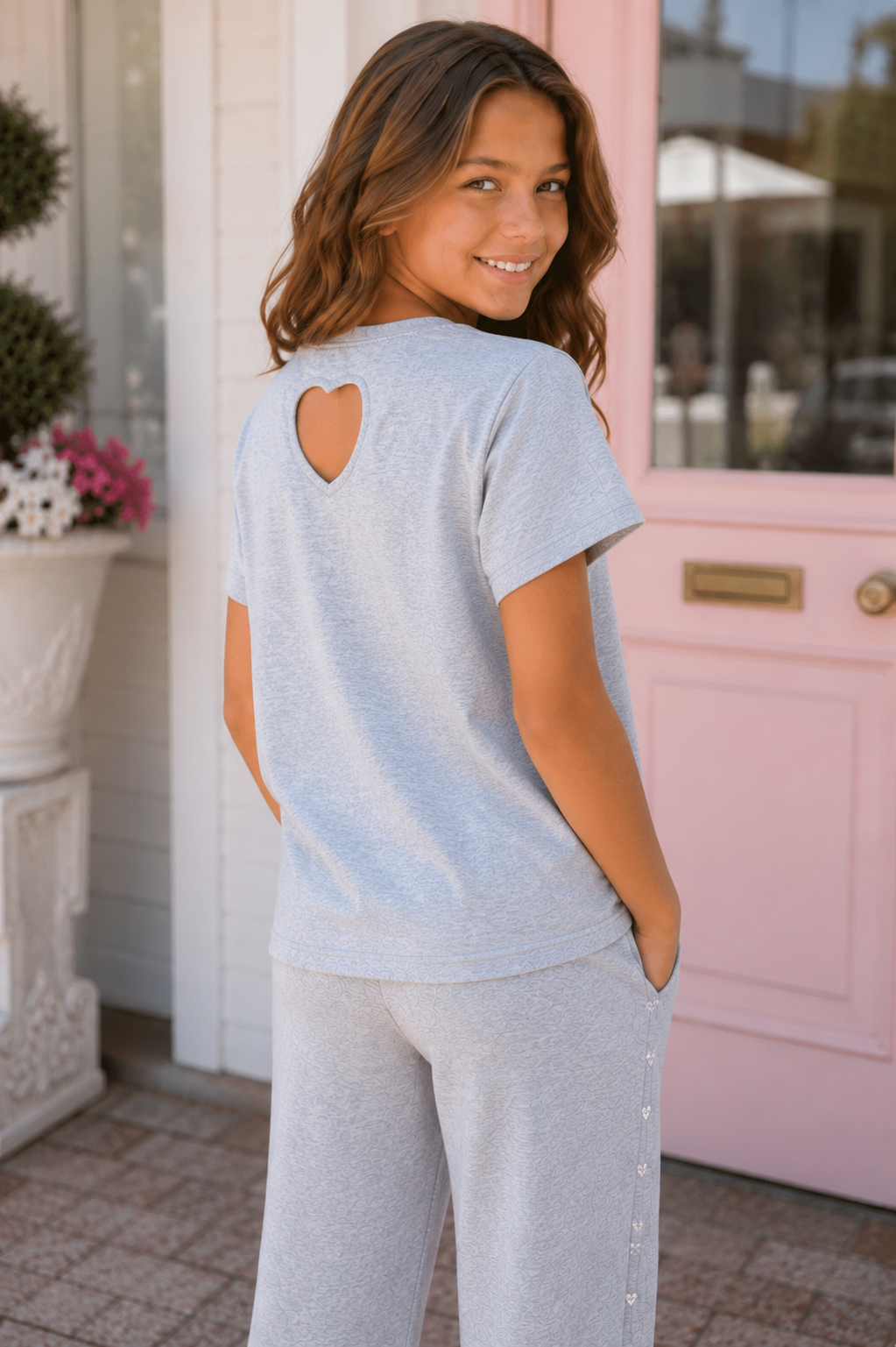 Tween girl wearing Rockwilde crystal heart tee with sparkling jeweled hearts and heart-shaped cutout on the back.