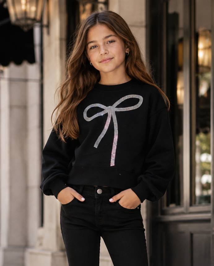 Tween girl wearing Lola + The Boys black rhinestone bow sweatshirt