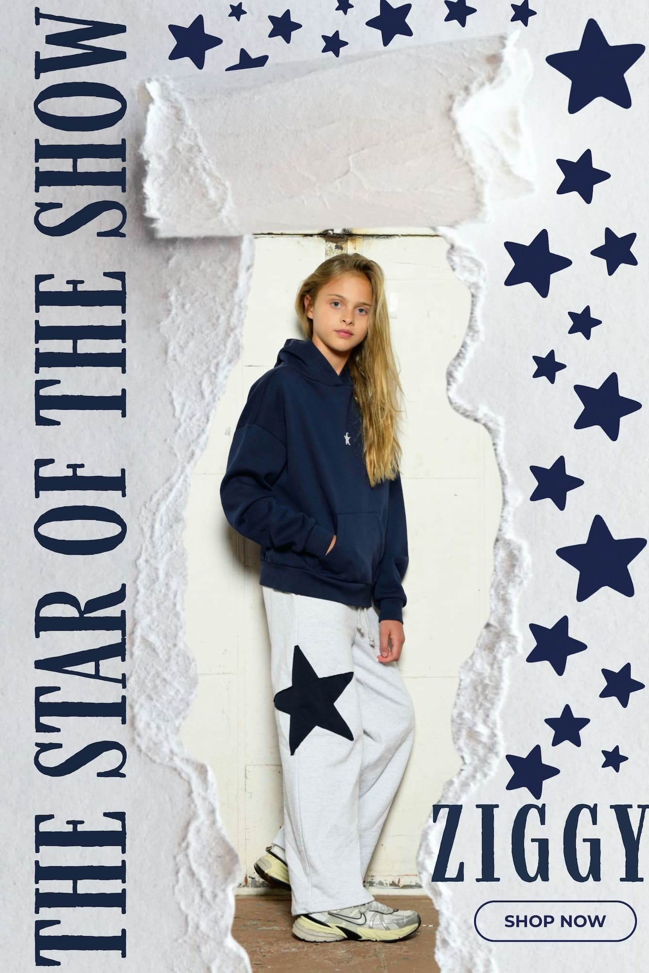 A young girl stands in a doorway wearing a navy blue hoodie and white sweatpants with a large navy star patch on one leg. The image is a promotional graphic with torn-paper borders, navy stars, the text 'THE STAR OF THE SHOW' on the left, 'ZIGGY' on the right, and a 'SHOP NOW' button at the bottom.