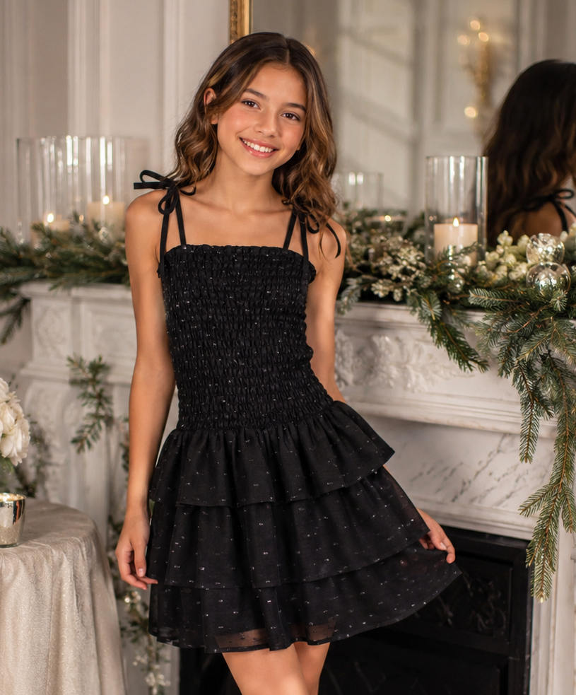 Tween girl wearing Summer Loving Belle Dress in black with smocked bodice, tie shoulder straps, and tiered ruffle skirt.