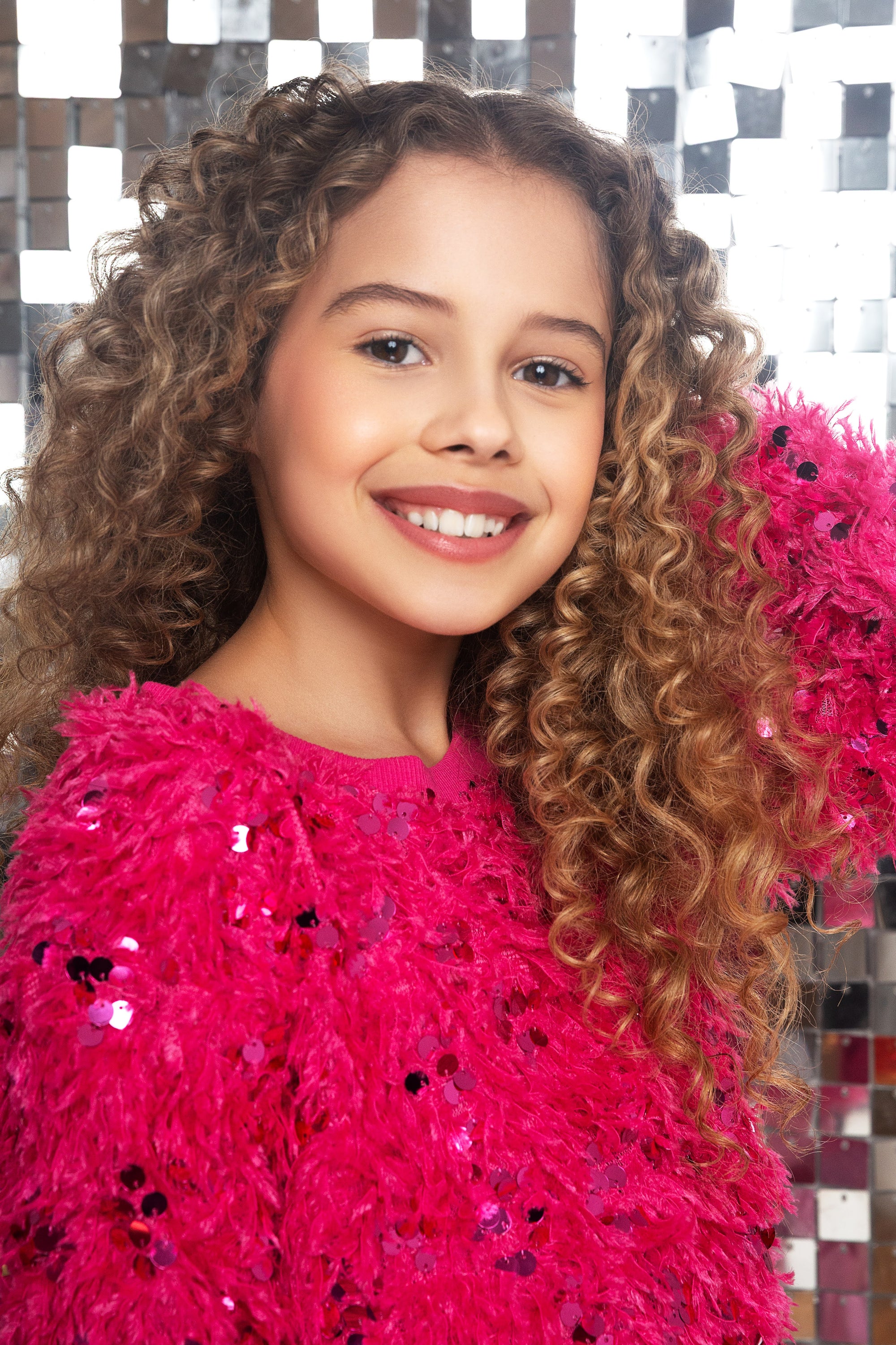 tween girl wearing a cozy hot pink sweater with sequins from MIA NY