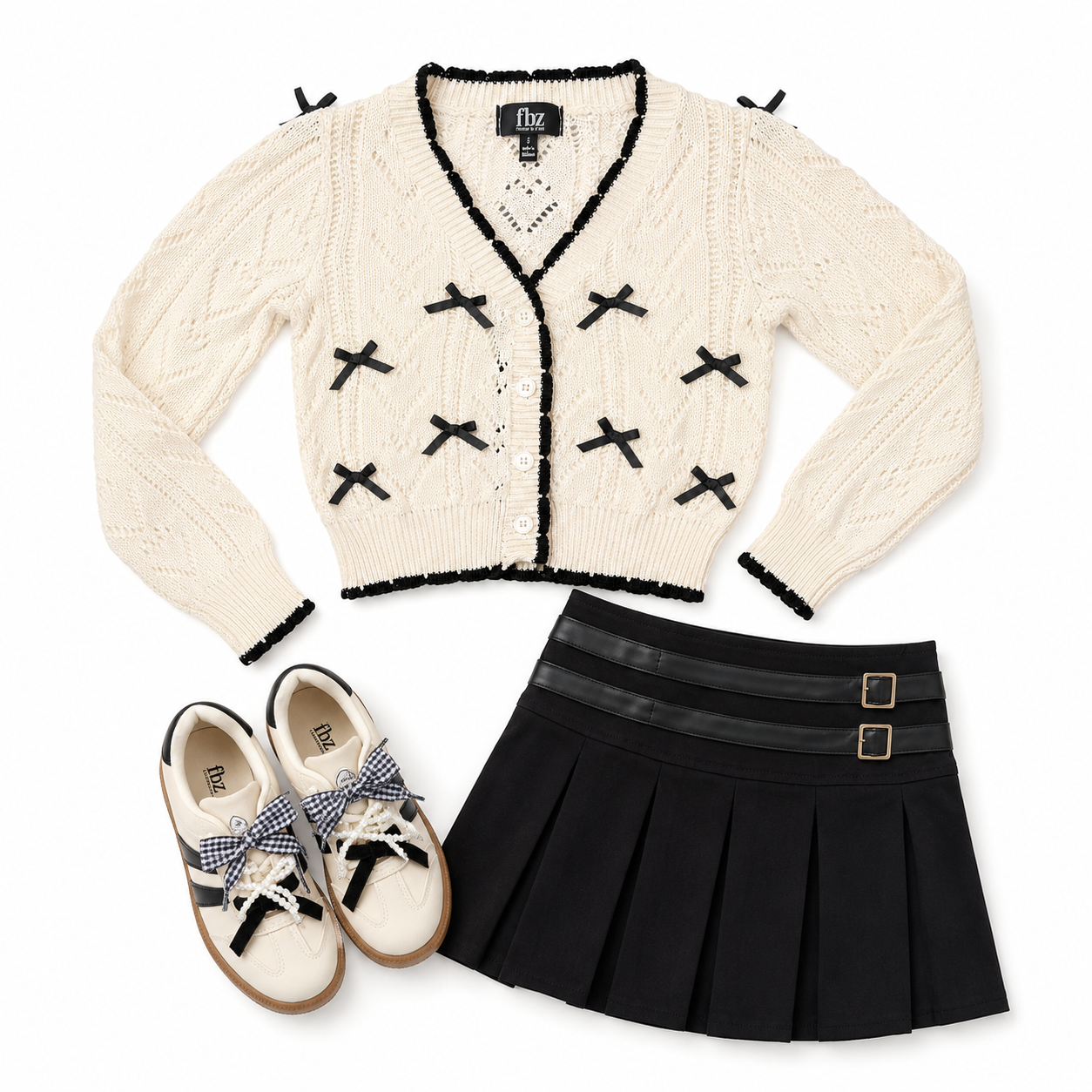 A flat-lay outfit set featuring an off-white cable-knit cardigan with black trim and bow details by FBZ a black pleated mini skirt with a wide black waistband and gold-tone buckle, and cream canvas sneakers with blue gingham bows and black side stripes. The brand  FBZ is visible on the cardigan label, insole of the shoes, and on the skirt.