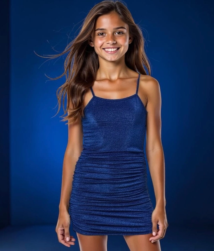 Tween girl wearing the Gold Rush NYC Skyler Capri Blue shimmer dress with ruched fit and adjustable straps.